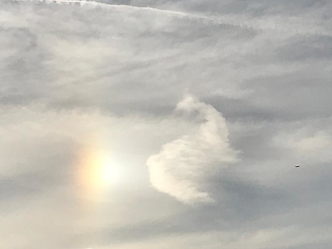 Wind blown clouds featuring a rainbow flare